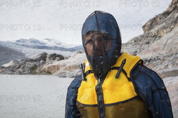 Man with mosquito net at fjord