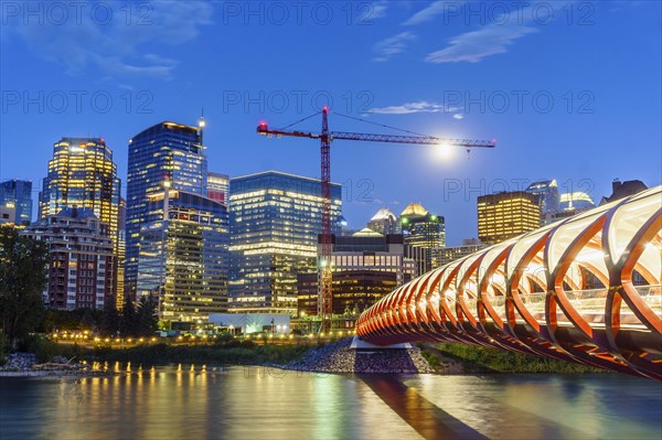 Calgary downtown at dusk with Peace Bridge over Bow river