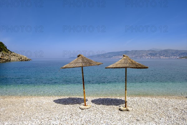 Reed-covered parasols on the gravel beach