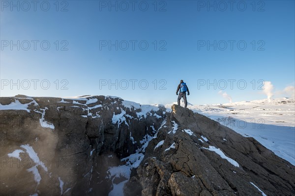 Mountain hiker stands at Continental Rift between North American and Eurasian Plate