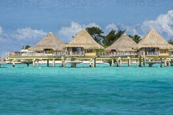 Overwater bungalows on stilts in luxury hotel