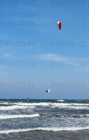 Kitesurfer in the air over sea with waves