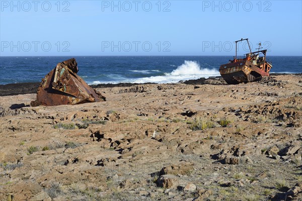Rusty wreck of a fish trawler on the rocky shore