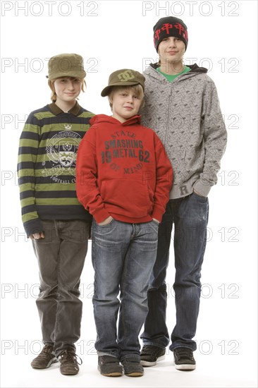3 boys between the ages of 9 and 13, wearing caps