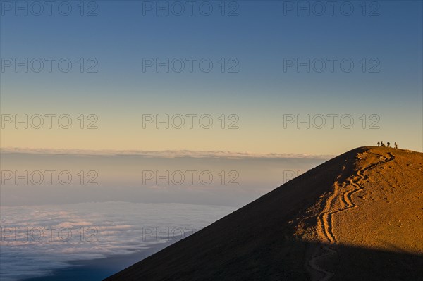 Tourists on a volcanic cone on top of Mauna Kea