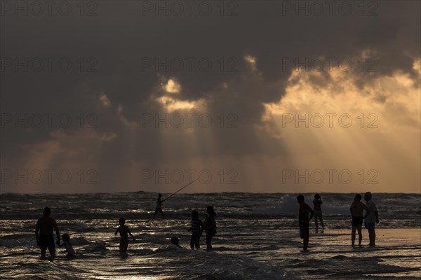 People in backlight on beach