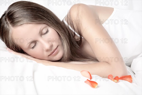 Young woman sleeping in white bed