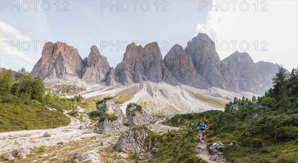 Hiking on footpath to the Geisleralm in the Villnos valley below the Geisler Peaks