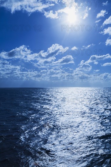 Late afternoon sun through cumulus clouds over the Mediterranean sea off the coast of Italy