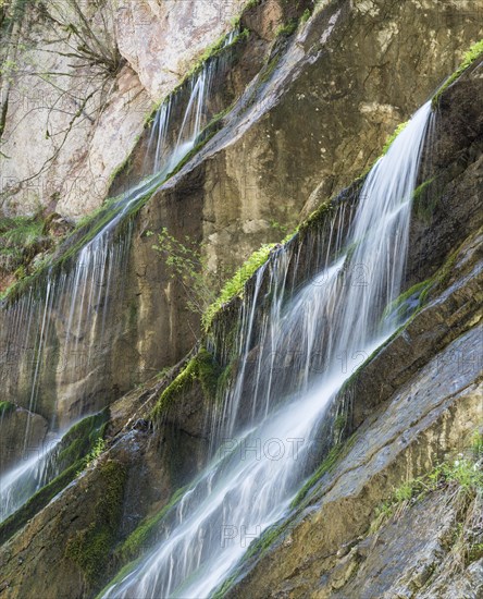 Waterfall on mossy slope in gorge