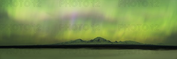 Aurora over the fog shrouded Copper River and mounts Sanford Drum and Wrangell