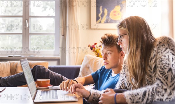 Two students sitting in front of a laptop