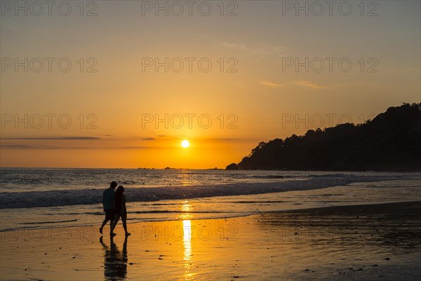 Man and woman strolling on the beach