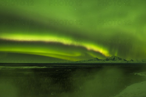 Aurora over the fog shrouded Copper River and mounts Sanford Drum and Wrangell