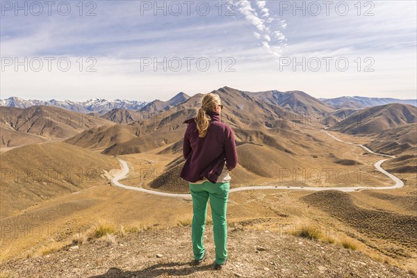 Woman looking over stark mountains