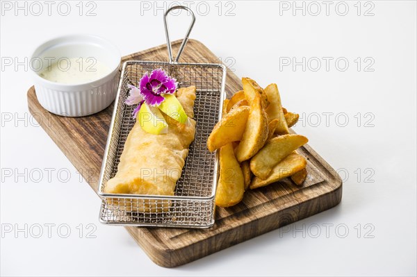 Fried hake fillet in batter with potato wedges and Sauce Tartar