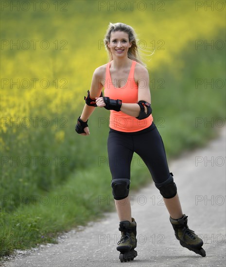 Inline skating alongside blooming rape field