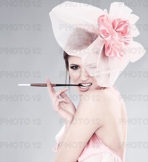 Young woman with hat and cigarette holder