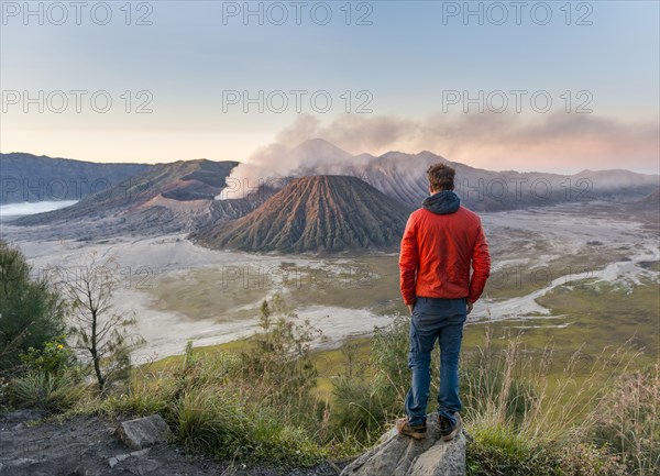 Tourist in front of landscape at sunset