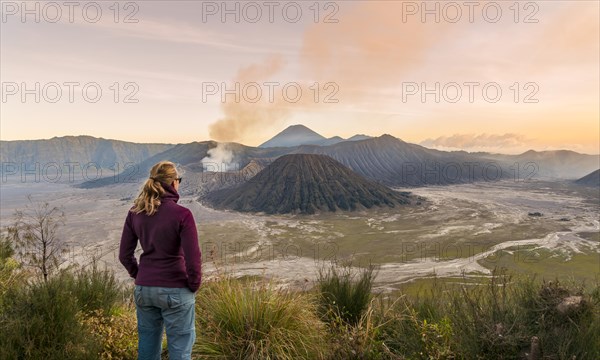 Tourist in front of landscape at sunset