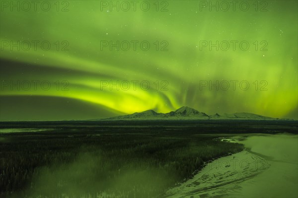 Aurora over the fog shrouded Copper River and mounts Sanford Drum and Wrangell