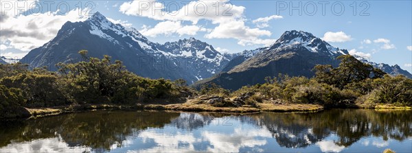 Small mountain lake with reflection of the mountain chain