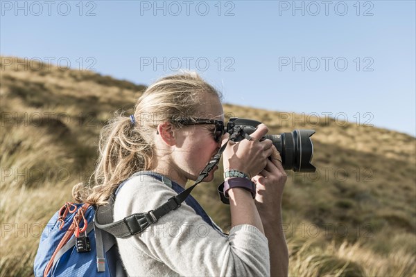 Female hiker taking picture with a reflex camera