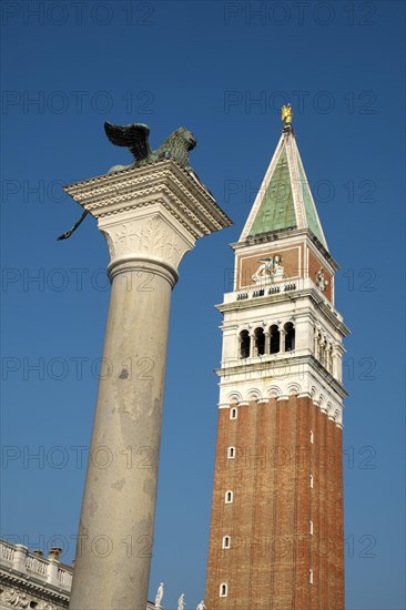 Winged lion on granite column with church tower of Basilica di San Marco