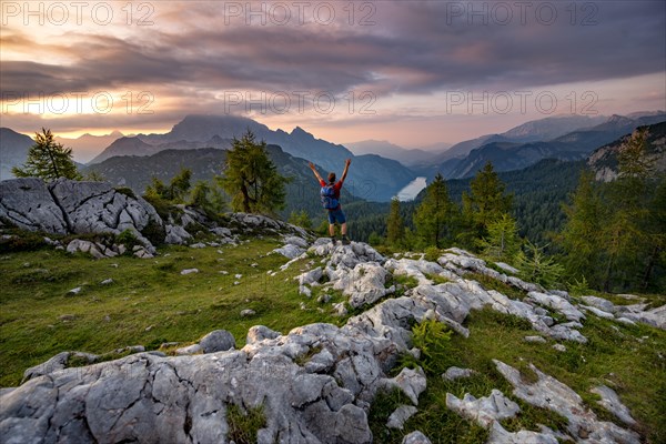 Hiker stretches his arms into the air