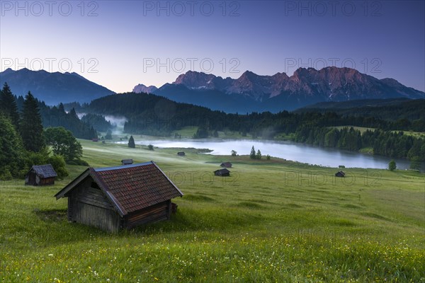 Small cabin on mountain meadow at forest edge