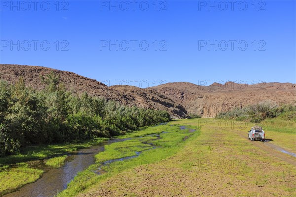 Off-road vehicle drives in the Hoarusib river bed