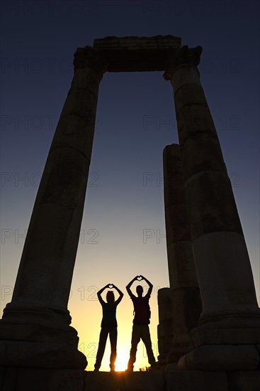 Couple forms a heart in sunset at the Temple of Hercules at the Citadel