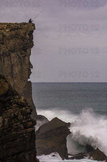 Cliff fisher at steep coast