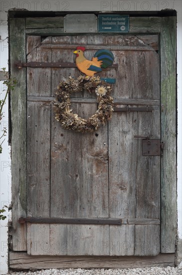 Stable door with a wreath and cock figure