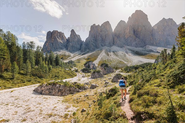 Hiking on footpath to the Geisleralm in the Villnos valley below the Geisler Peaks