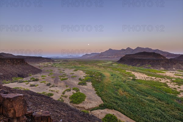 Moon rising in dry river valley