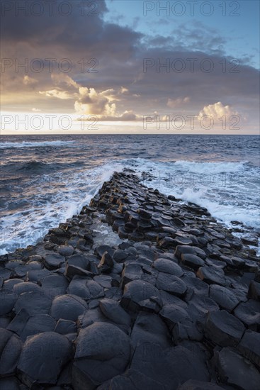 Basalt columns by the coast at sunset