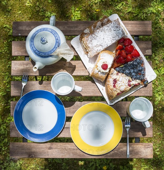 garden table with tea service various cakes and tea