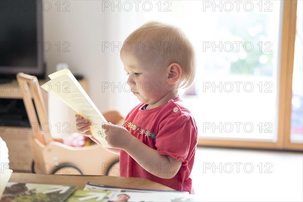 Toddler looking very interested at a text