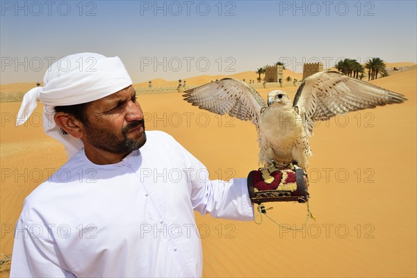 Falconer in front of the desert luxury hotel Anantara Qasr Al Sarab