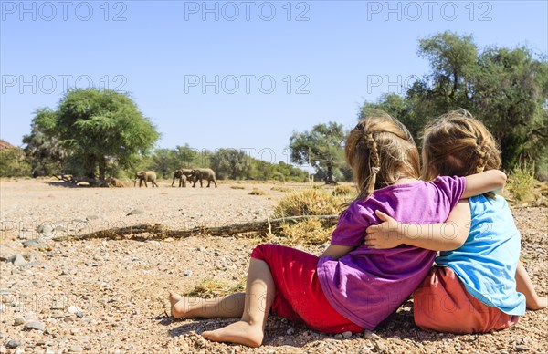 Two girls watching elephants