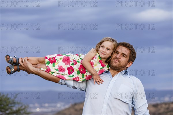 Father holding his baby daughter in his arm