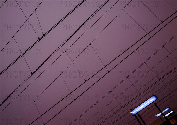 Overhead lines and station sign Amsterdam Centraal at night