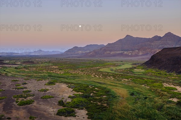 Moon rising in dry river valley