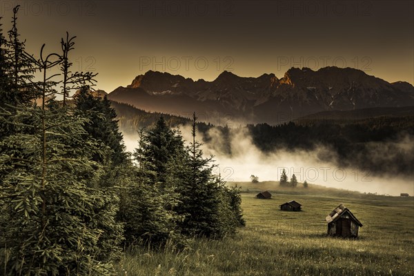 Small cabin on mountain meadow at forest edge