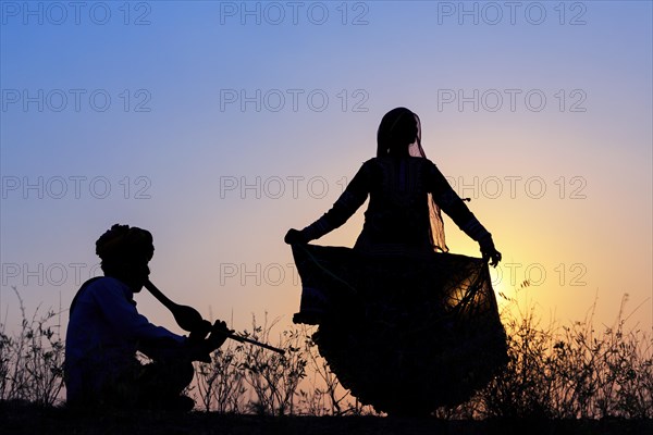 Indian gypsy dancing in front of setting sun