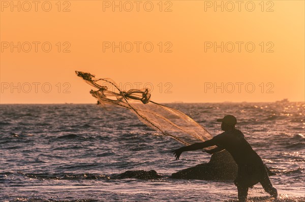 Local fisherman casts fishing net