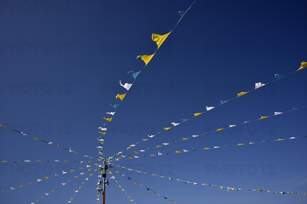 Colorful pennant against a blue sky at a festival