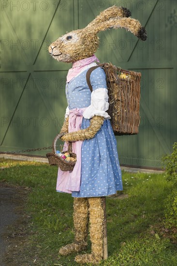 Easter bunny as straw doll with egg basket