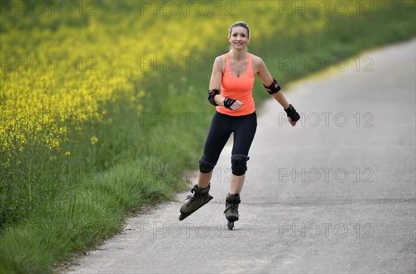 Inline skating alongside blooming rape field